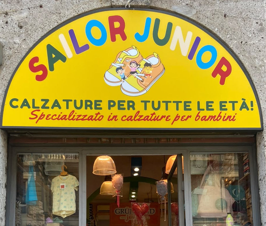 Bambini e un adulto decorano insieme un paio di scarpe